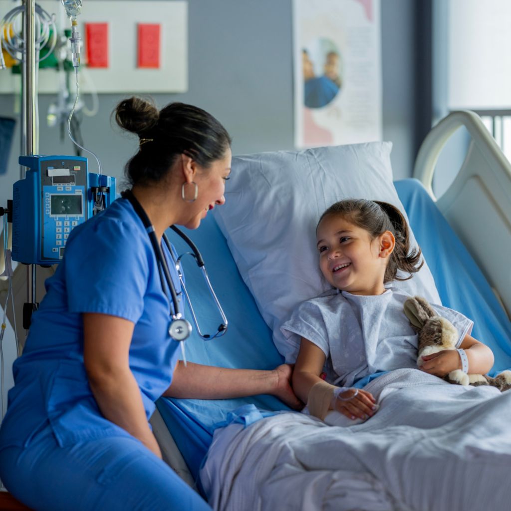 Medical professional speaking with child in hospital bed