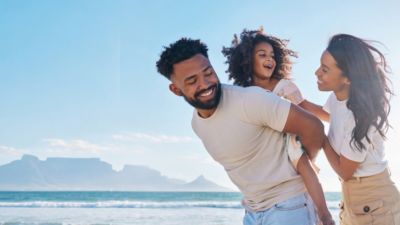 Parents and child walking together along a beach