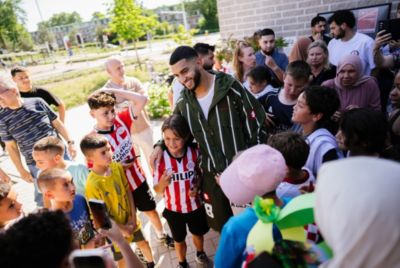 Foto Saibari die poseert met jongetje: De AED is geplaatst bij wijkcentrum De Uitwijk in Eindhoven