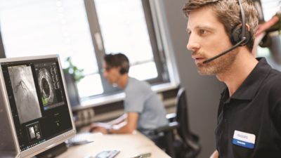 Philips specialist providing remote clinical support while viewing medical imaging on a monitor