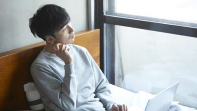 窓際に座って思慮深い表情を浮かべている男