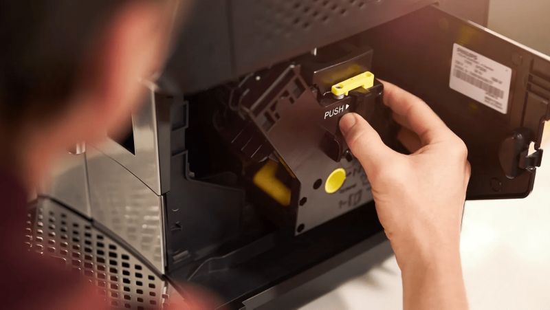 שליפת יחידת החליטה של Philips 800 מהדלת הצדדית של המכונה לצורך שטיפה